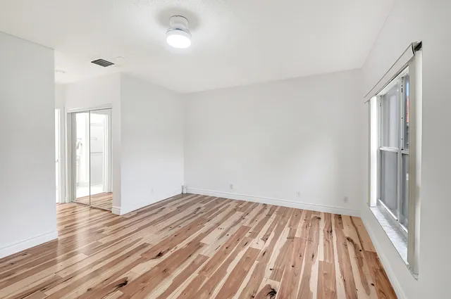 a view of room with window and wooden floor