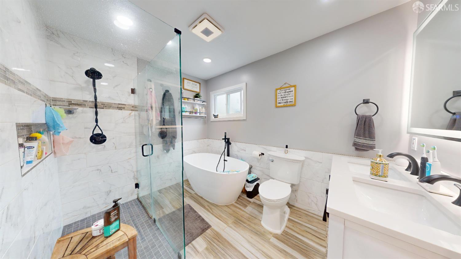 1155 Crespi Drive Pacifica, CA 94044 - Photo 11 of 29 full master bath featuring tile walls, a freestanding tub, double vanity, a stall shower, and recessed lighting