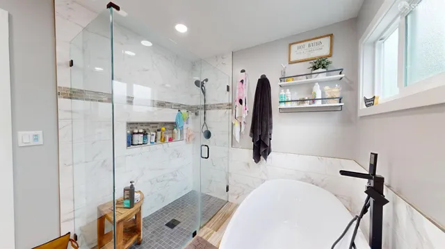a bathroom with a tub sink shower and mirror