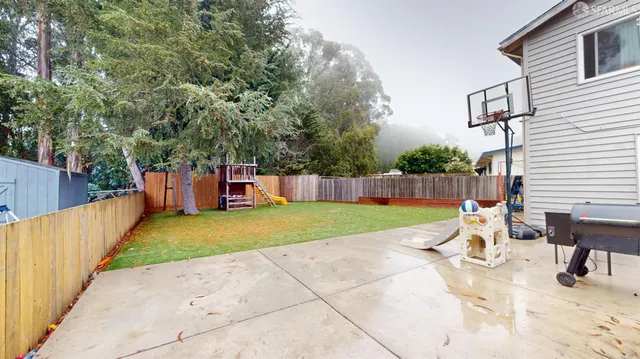 a view of a house with backyard and a tree