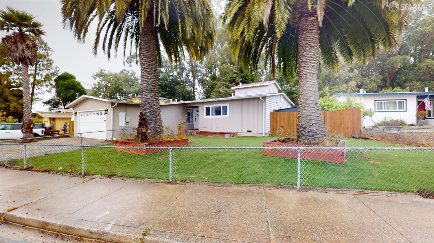 1155 Crespi Drive Pacifica, CA 94044 - Photo 2 of 29 ranch-style house with an attached garage, a fenced front yard, driveway, and stucco siding
