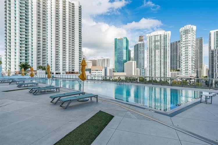 92 Southwest 3rd Street, Unit 1604 Miami, FL 33130 - Photo 17 of 18 a swimming pool with outdoor seating and water view
