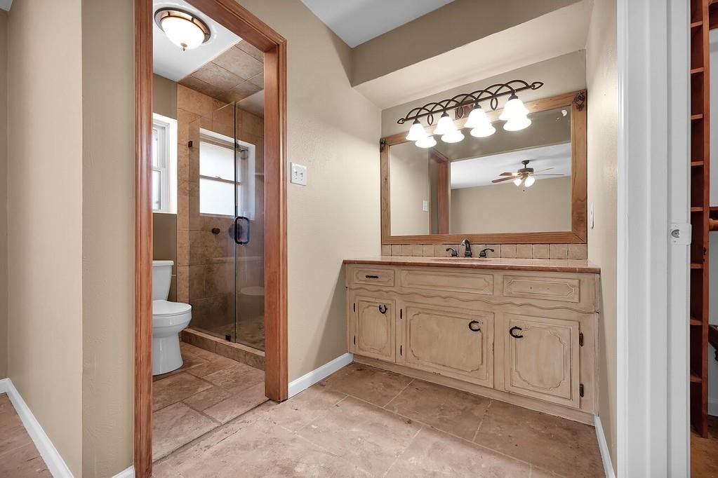 10235 White Rock Road Conroe, TX 77306 - Photo 19 of 25 a spacious bathroom with a granite countertop sink a toilet and a mirror