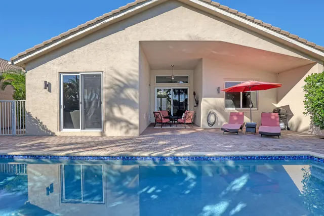 a view of swimming pool with a yard and palm trees