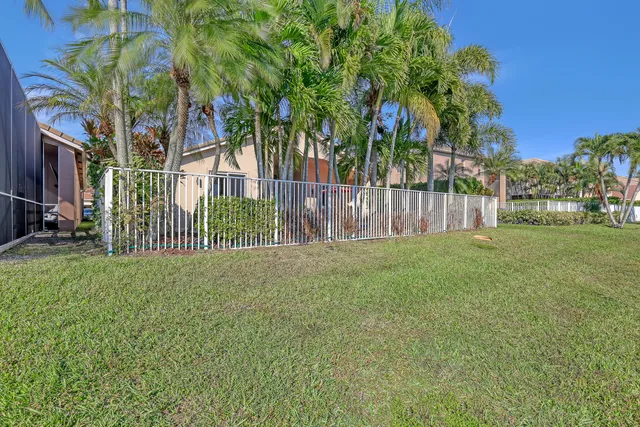 a view of a white house with a yard and potted plants
