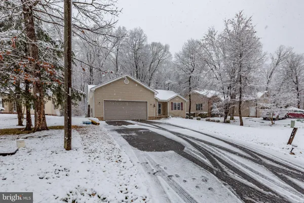 a front view of a house with a yard covered in snow