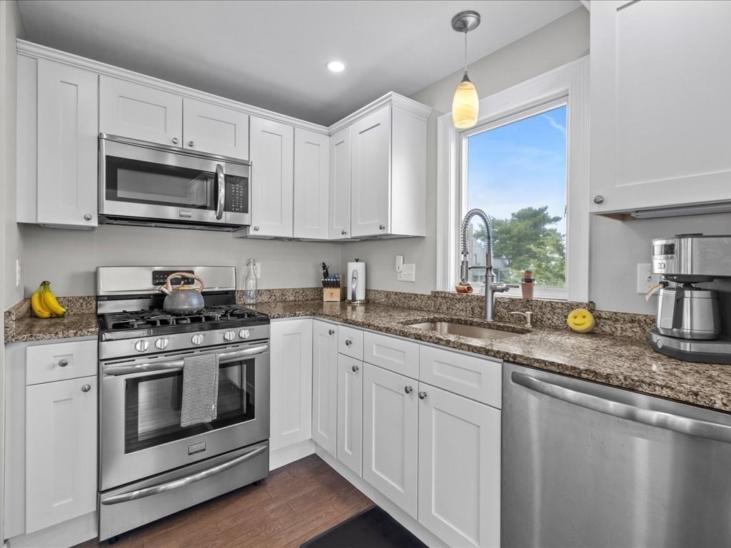 35 Cliff Road South Scituate, MA 02050 - Photo 8 of 42 a kitchen with stainless steel appliances granite countertop a sink a stove a microwave and wooden cabinets