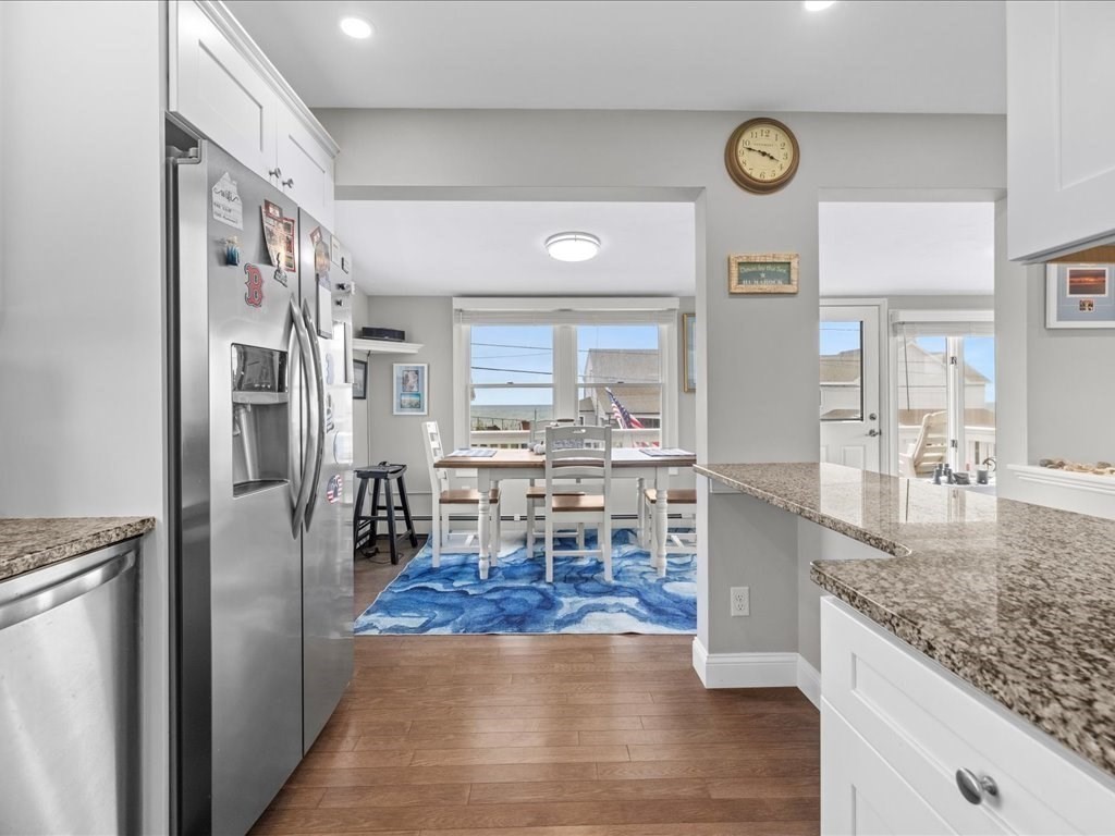 35 Cliff Road South Scituate, MA 02050 - Photo 9 of 42 a kitchen with stainless steel appliances granite countertop a refrigerator oven stove a dining table and chairs with wooden floor