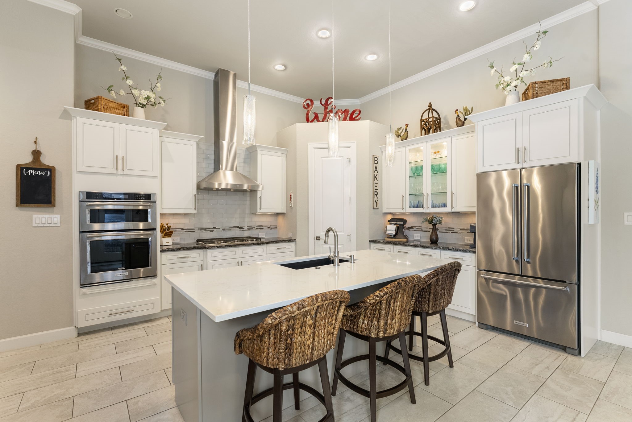 25607 Muirfield Bend Court Spring, TX 77389 - Photo 10 of 30 Gourmet kitchen featuring an oversized island, KitchenAid stainless steel appliances, custom cabinetry, and a spacious walk-in pantry.