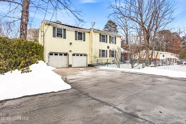 a white house that has a tree in front of it