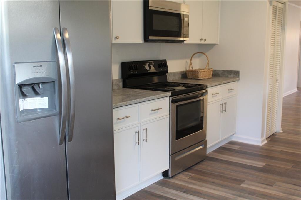1076 Grant Way Southeast Atlanta, GA 30315 - Photo 7 of 29 a kitchen with stainless steel appliances granite countertop a stove a microwave and a refrigerator