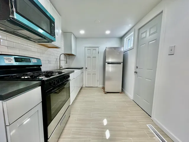 a kitchen with a refrigerator a stove and cabinets