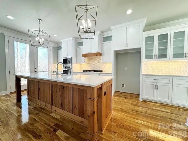 a kitchen with stainless steel appliances granite countertop a sink a stove and a refrigerator