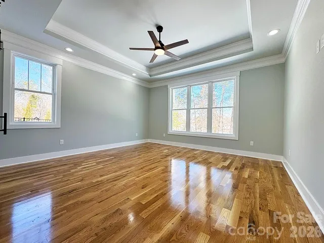 a view of a livingroom with a ceiling fan and wooden floor