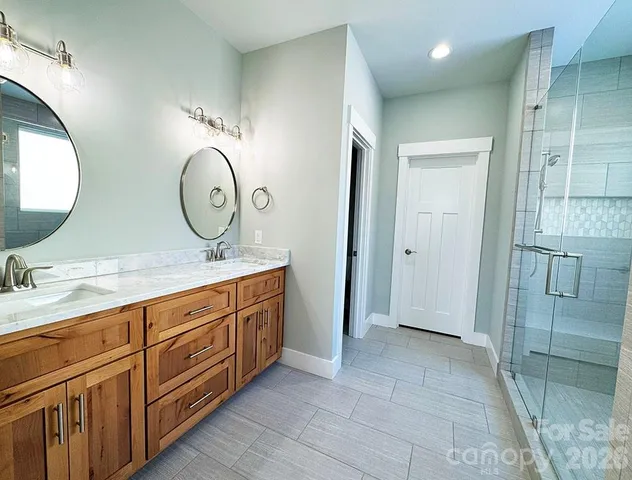 a bathroom with a granite countertop double vanity sink and a mirror