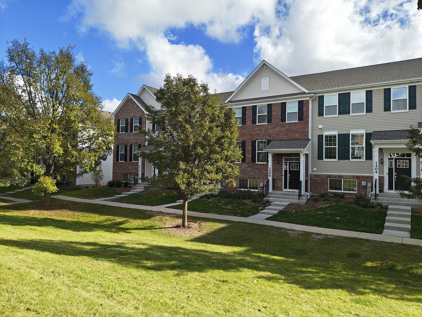1204 Neubauer Circle, Unit 1304 Lindenhurst, IL 60046 - Photo 2 of 29 a front view of a house with a yard table and chairs