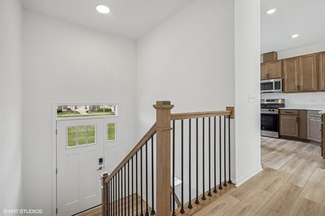 a view of an empty room with wooden floor and stairs