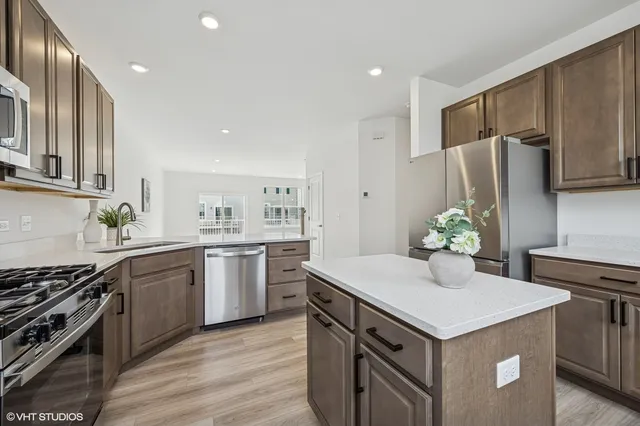 a kitchen with stainless steel appliances a refrigerator sink and wooden cabinets