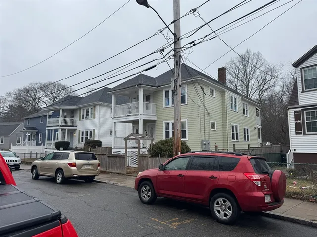 a car parked in front of a white house