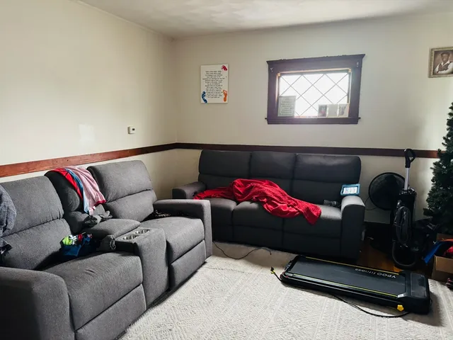 a living room with furniture a couch and the view of kitchen