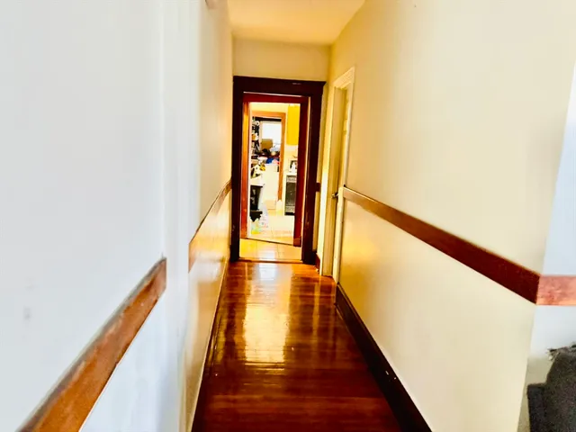a view of a hallway with wooden floor