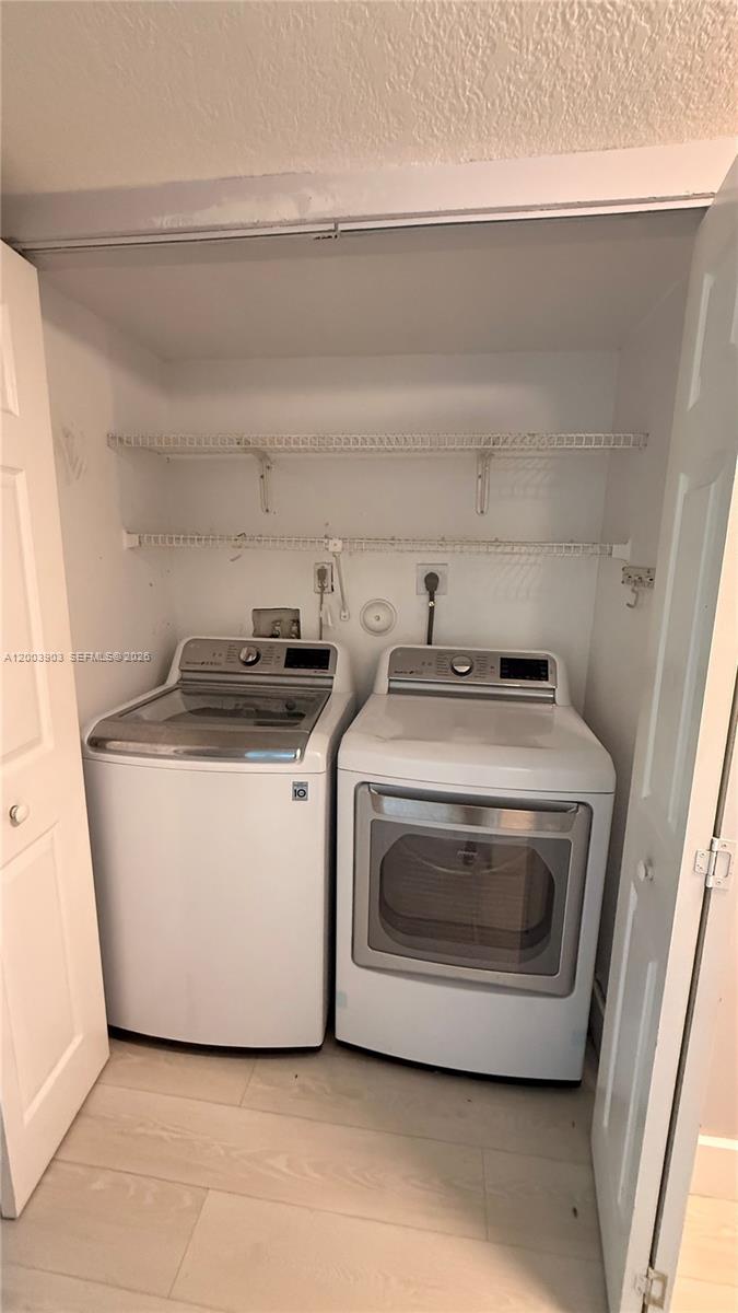 821 Lyons Road, Unit 21102 Coconut Creek, FL 33063 - Photo 13 of 17 a utility room with washer and dryer