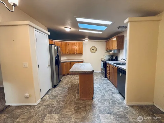 a kitchen with granite countertop a sink a stove and cabinets