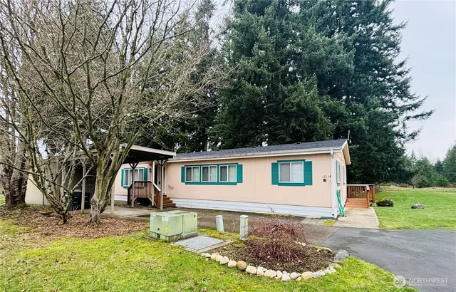 a view of a yard in front of a house with large tree