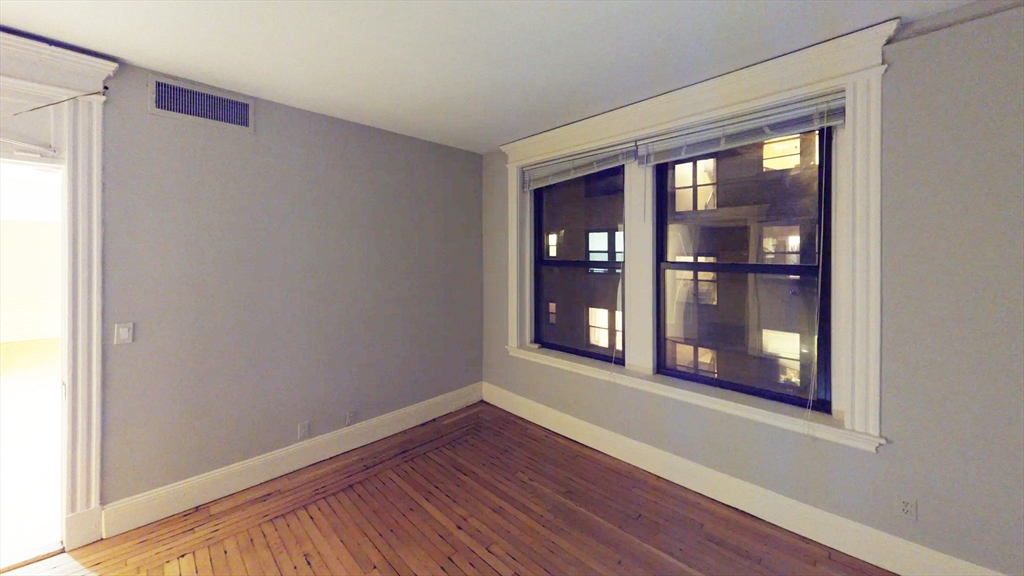 466 Commonwealth Avenue, Unit 406 Boston, MA 02215 - Photo 2 of 8 a view of an empty room with wooden floor and a window