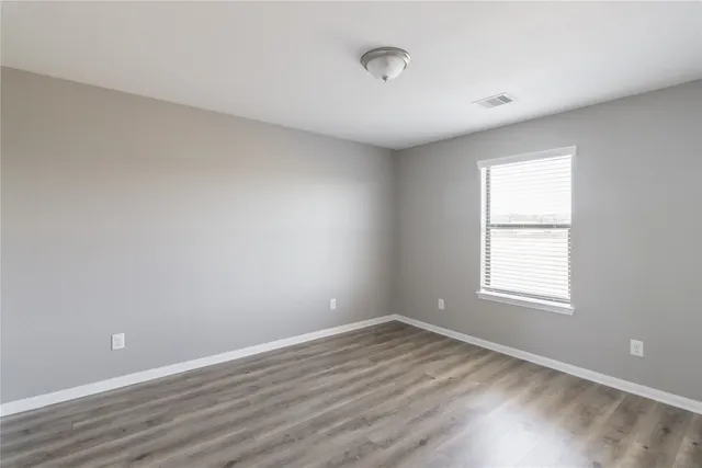a view of a hallway with a wooden floor and entryway