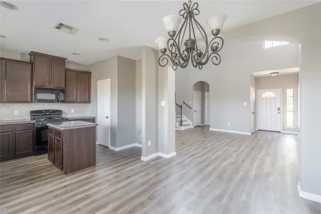 a kitchen with kitchen island stainless steel appliances granite countertop a sink and cabinets