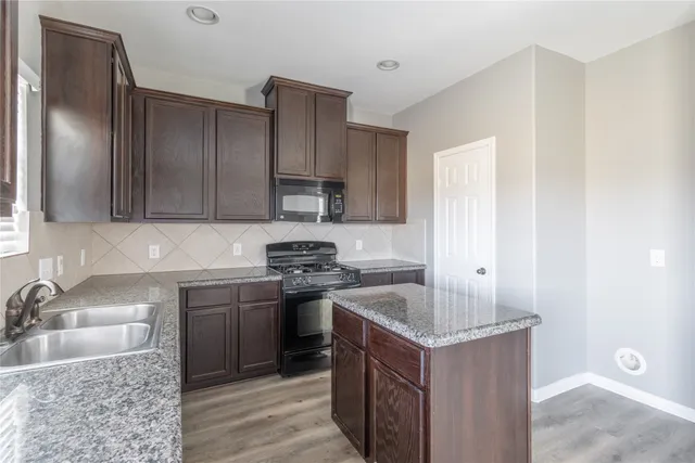a kitchen with a sink stove and cabinets