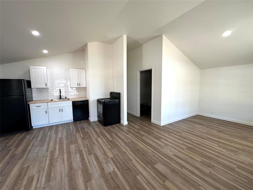 a view of kitchen with granite countertop cabinets and refrigerator