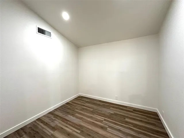 a kitchen with a refrigerator and white cabinets