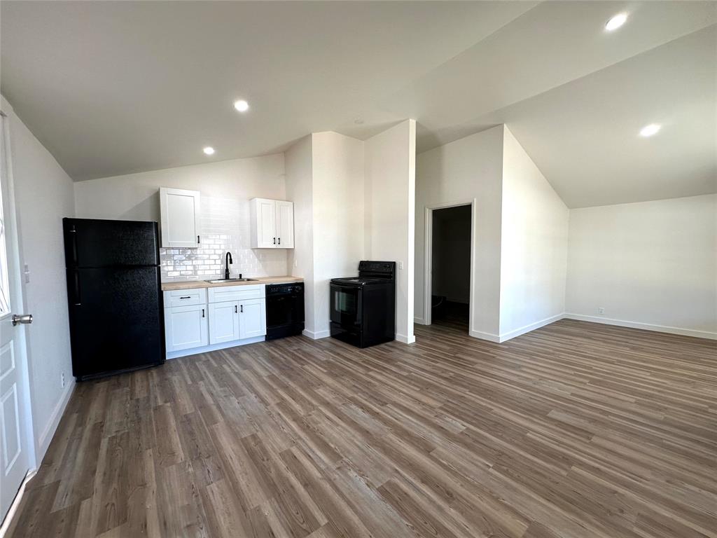 102 North Pinto Street Comanche, TX 76442 - Photo 15 of 23 a view of kitchen with stainless steel appliances kitchen island wooden cabinets and granite counter tops