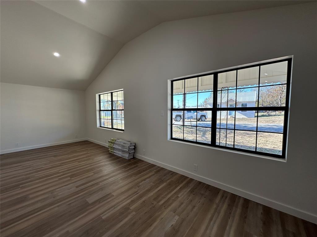 102 North Pinto Street Comanche, TX 76442 - Photo 17 of 23 a view of an empty room with wooden floor and a window