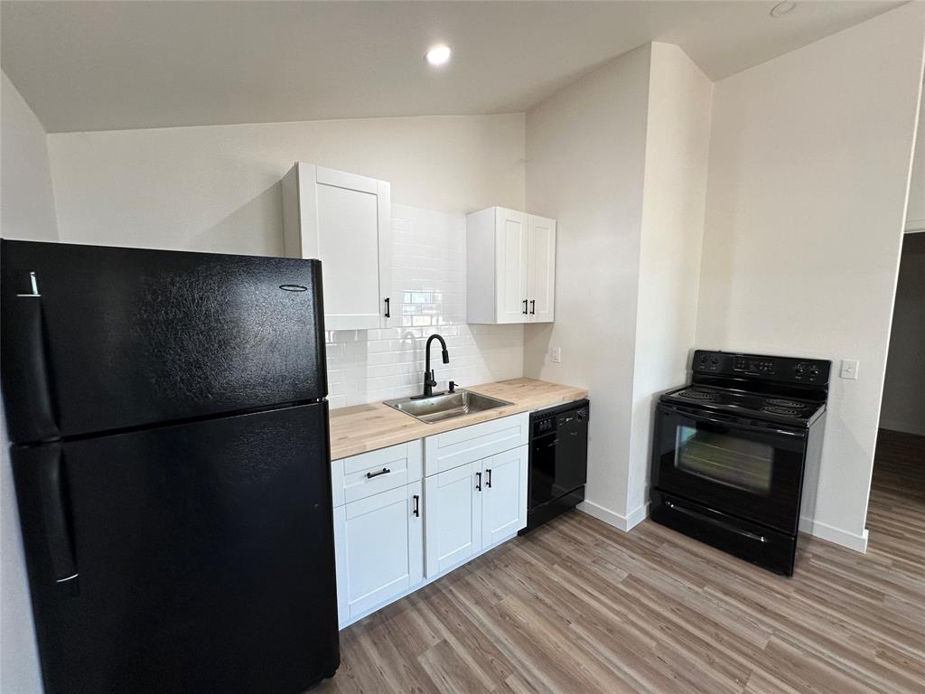 102 North Pinto Street Comanche, TX 76442 - Photo 18 of 23 a kitchen with a refrigerator stove and sink