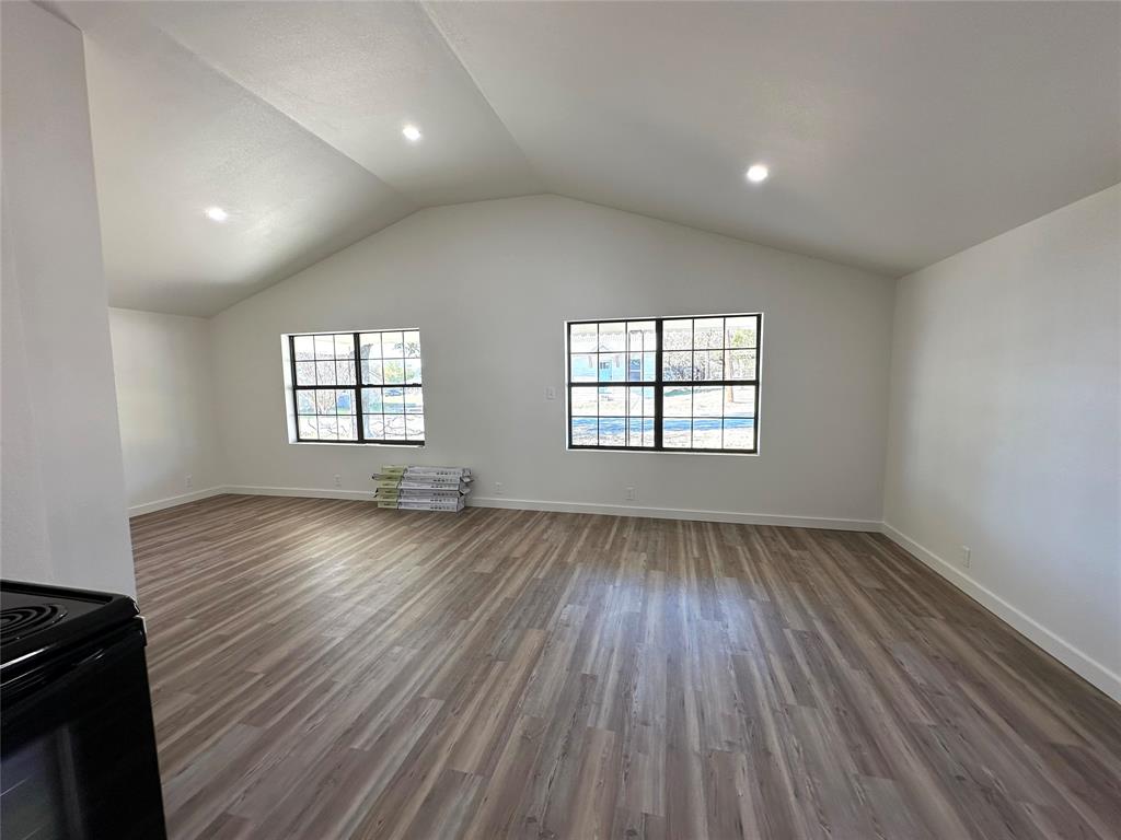 102 North Pinto Street Comanche, TX 76442 - Photo 5 of 23 an empty room with wooden floor and windows