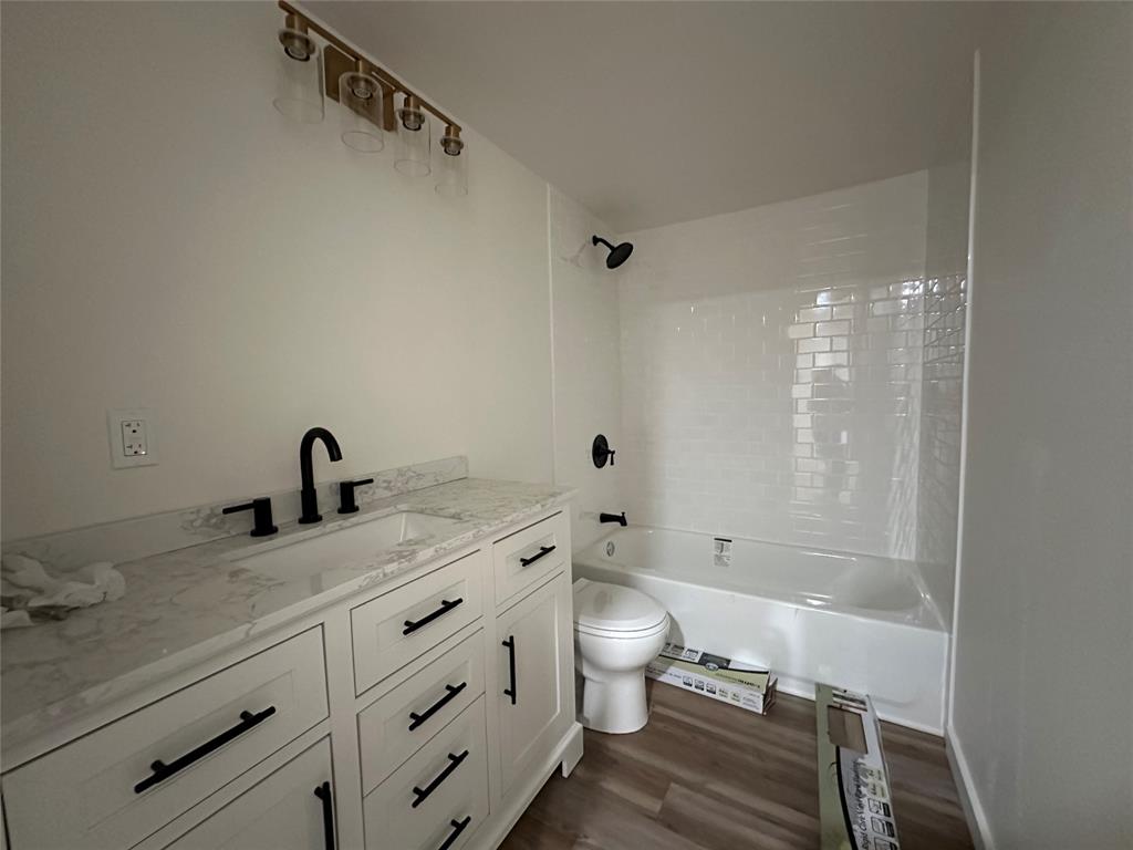 102 North Pinto Street Comanche, TX 76442 - Photo 10 of 23 a bathroom with a granite countertop sink a toilet and shower