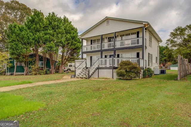 a view of a big house with a big yard and large trees