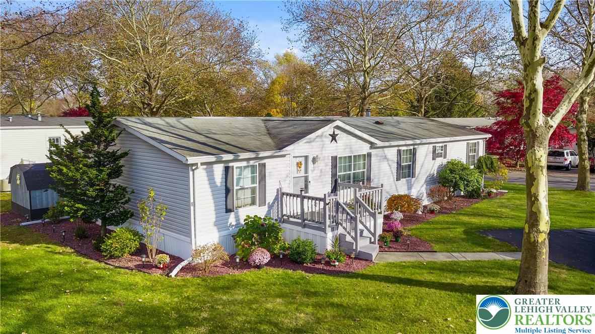 a view of a white house with a yard table and chairs
