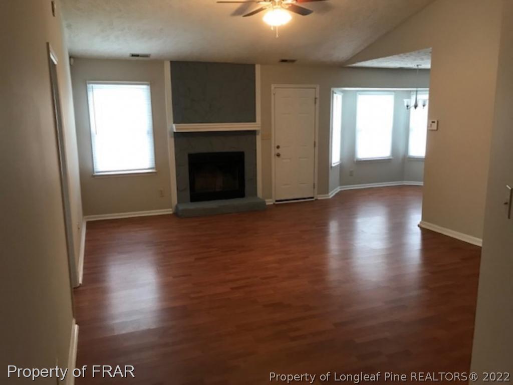 6140 Rhemish Drive Fayetteville, NC 28304 - Photo 2 of 12 a view of a livingroom with wooden floor a fireplace and window