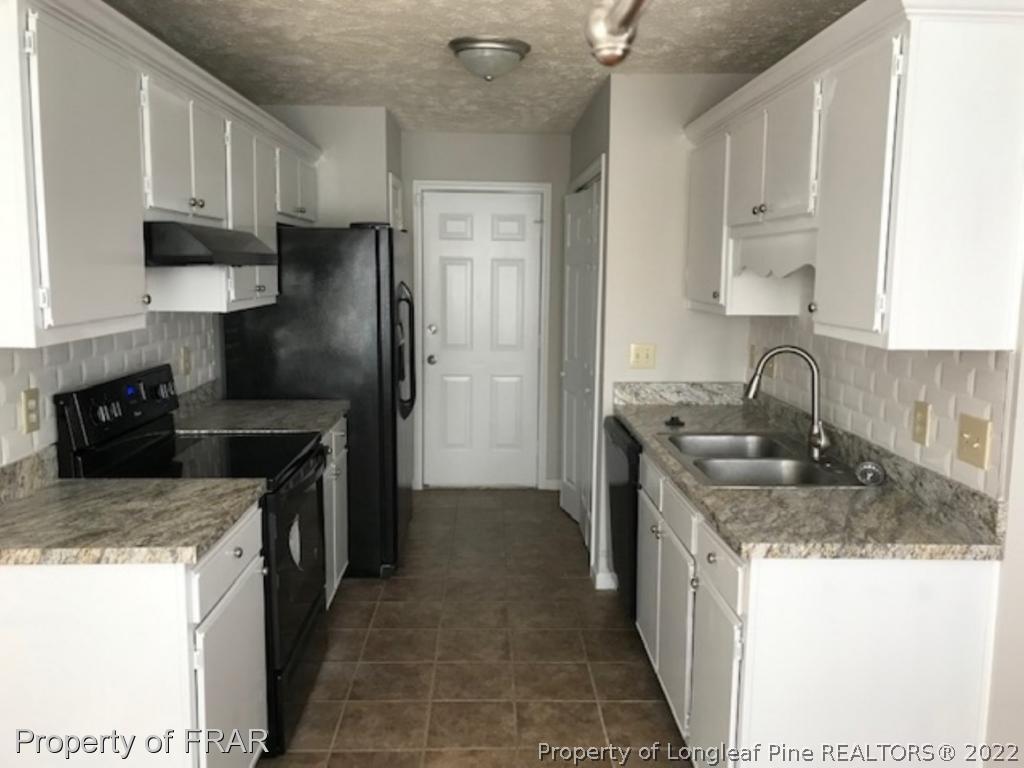 6140 Rhemish Drive Fayetteville, NC 28304 - Photo 3 of 12 a kitchen with stainless steel appliances granite countertop a sink stove and refrigerator