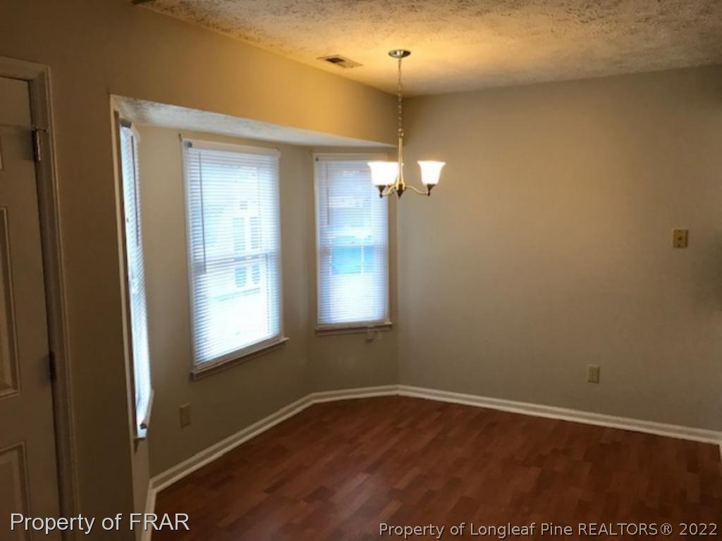 6140 Rhemish Drive Fayetteville, NC 28304 - Photo 4 of 12 an empty room with wooden floor and windows