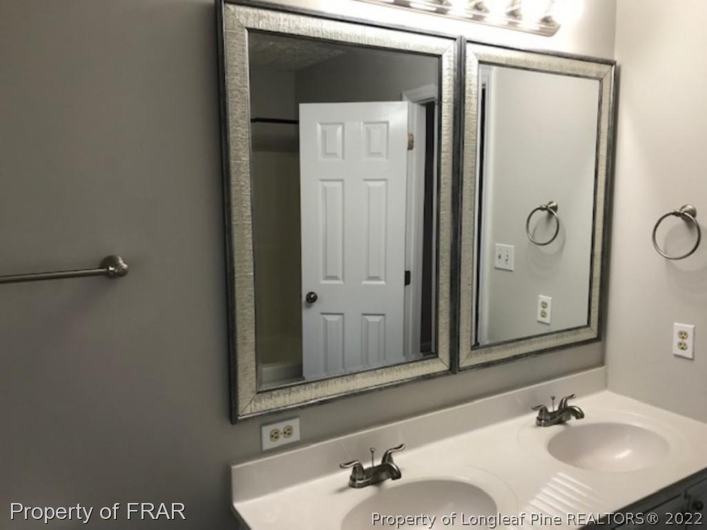 6140 Rhemish Drive Fayetteville, NC 28304 - Photo 7 of 12 a bathroom with a sink and a mirror