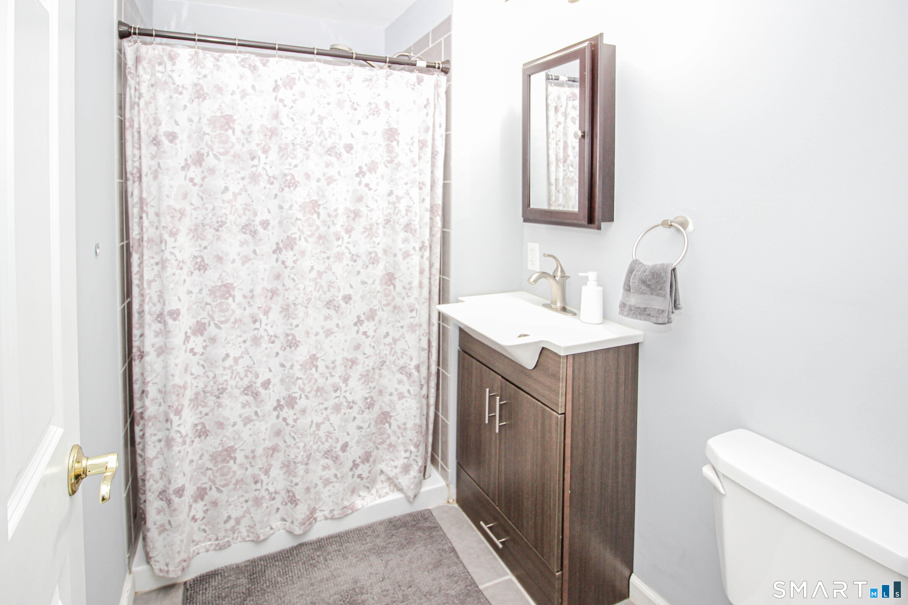 235 Lucille Street Newington, CT 06111 - Photo 30 of 35 a bathroom with a sink a toilet and shower curtain