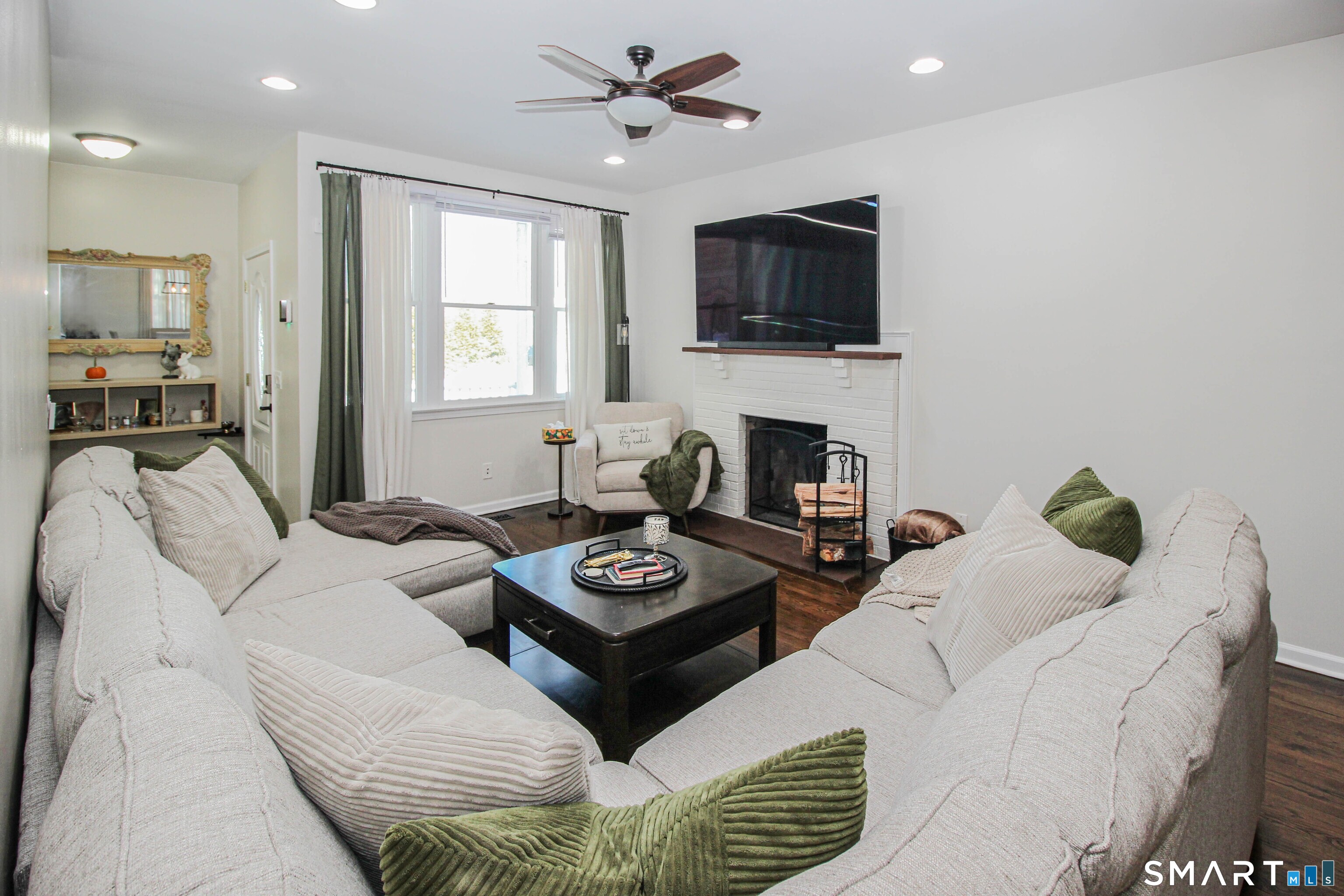235 Lucille Street Newington, CT 06111 - Photo 5 of 35 a living room with furniture a flat screen tv and a fireplace