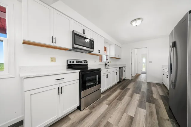 a kitchen with white cabinets and white appliances