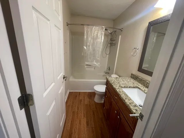 a bathroom with a granite countertop sink toilet and shower