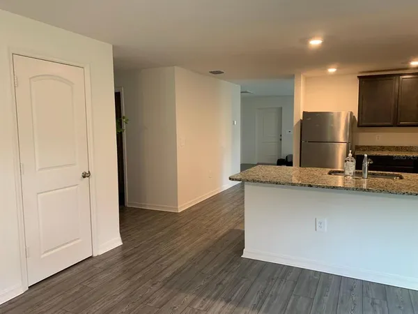 a kitchen with stainless steel appliances granite countertop a sink a refrigerator and a microwave